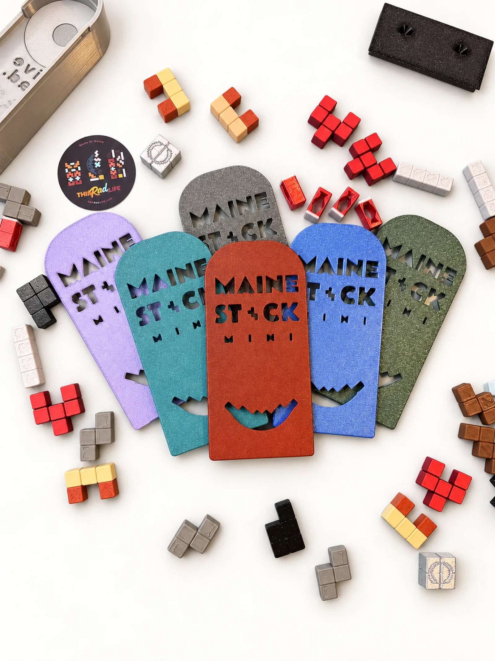 Maine Stack Mini covers in several colors surrounded by game pieces.